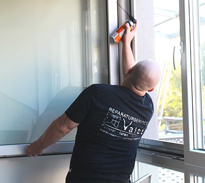 Ein Handwerker der eine Fensterdichtung anbringt.