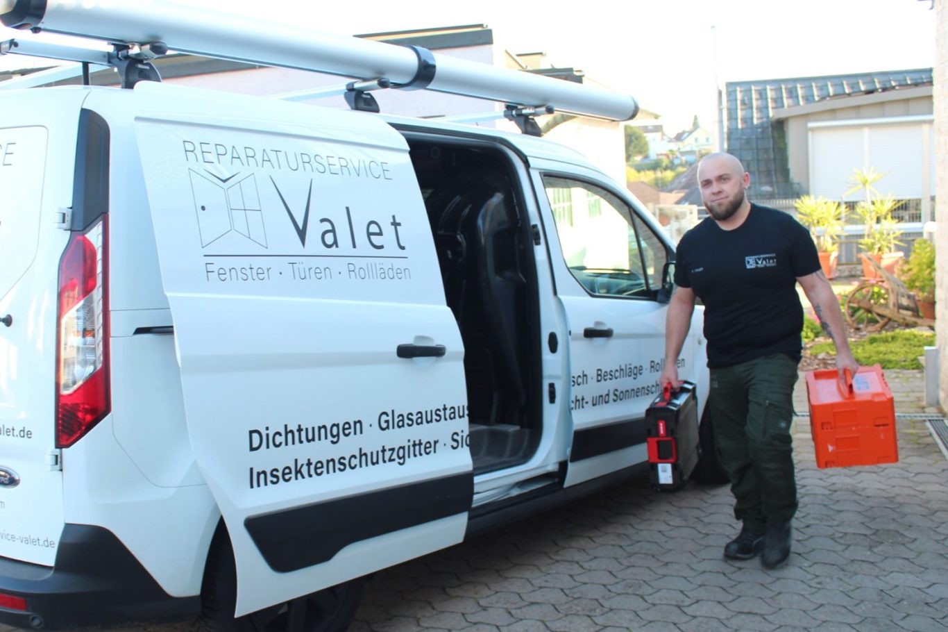 Mann mit Werkzeugkiste verlässt ein Fahrzeug mit „Valet“-Logo.