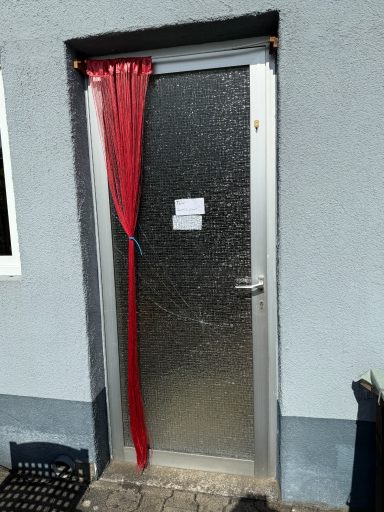 Tür mit rotem Vorhang und einer matten, strukturierten Oberfläche.